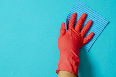 Employee hand in rubber protective glove with micro fiber cloth wiping wall from dust. Maid or housewife cares about house. Spring general or regular clean up. Commercial cleaning company conceptの写真素材