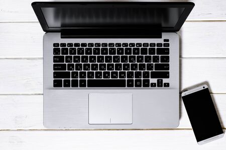 Minimal Freelancer workplace concept top view. Open laptop with blank screen on a white background...