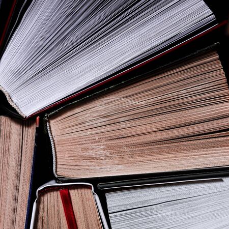Books. Lots of colourful thick open books stand on a dark background. ready to read