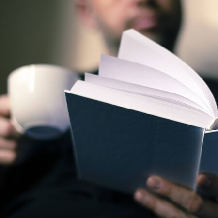 Men's hands hold a white book. Close-up