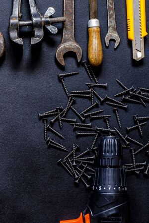 Hand tools for repair and reconstruction in home conditions lie on a black background. copy space