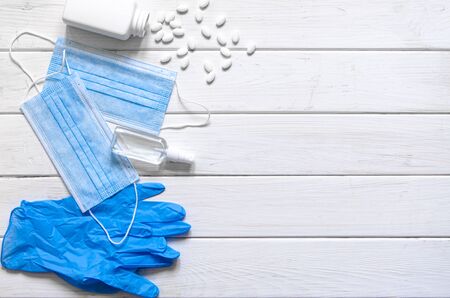 A pair of thin blue medical latex gloves and face shield on a white background. Disposable rubber medical gloves and mask. Protective subjectsの写真素材
