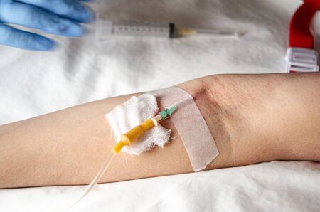 The needle of the drip stands in the vein for the introduction of vitamins intravenously. Invasive therapy. World blood donor dayの写真素材