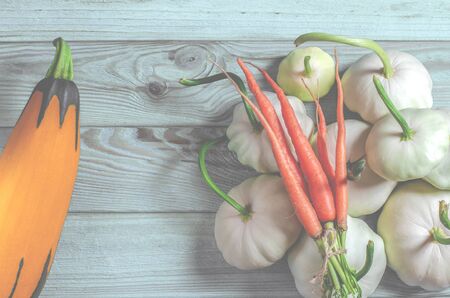 Vegetable set: carrots, patisons with green tails and multi-colored zucchini lie on an old wooden...