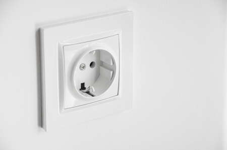 The white plastic socket is mounted in a white wall