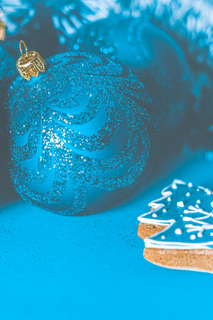 Christmas card: A blue Christmas tree toy lies on a blue background. Close-up