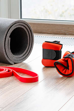 Sports concept for sports at home. Fitness mat, weights for arms and legs, harness for fitnessの写真素材