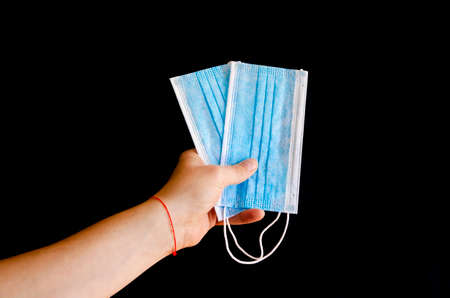 Virus protection. Blue medical protective surgical masks in the man's handの写真素材