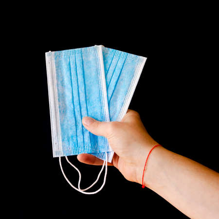 Virus protection. Blue medical protective surgical masks in the man's handの写真素材