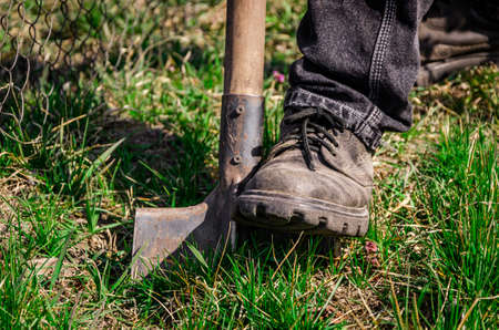 Digging spring soil with shovel. Close-up, shallow DOF.の写真素材