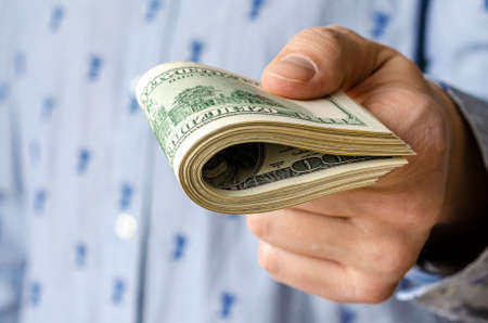 Business Man Displaying a Spread of Cash over a green vintage backgroundの写真素材