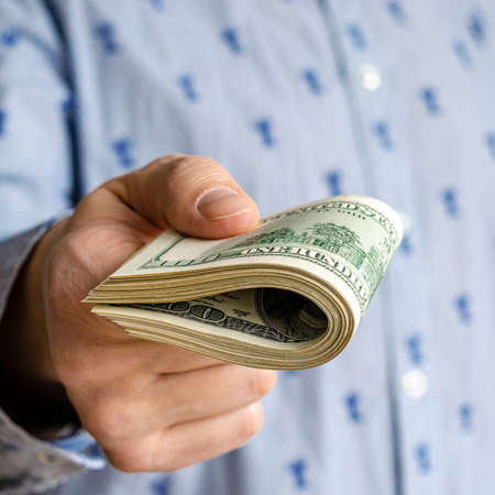 Business Man Displaying a Spread of Cash over a green vintage background