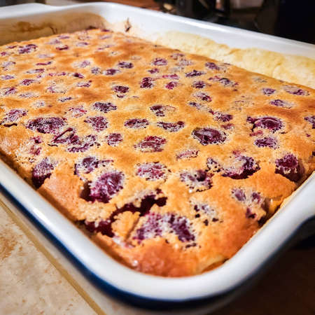 Homemade pastries. A ruddy homemade cherry pie stands on the table in a baking dish. Autumn food concept.の写真素材