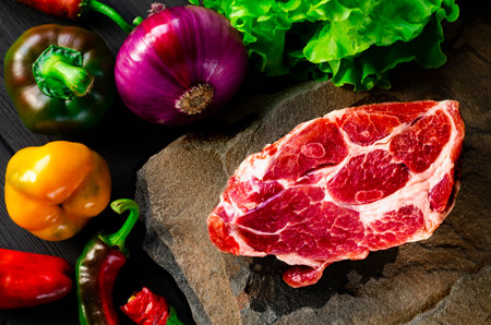 Picnic set. Juicy marble steak and fresh vegetables lie on the stoneの写真素材