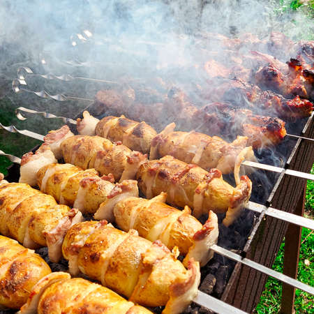 Young potatoes are wrapped in bacon and baked on the grillの写真素材