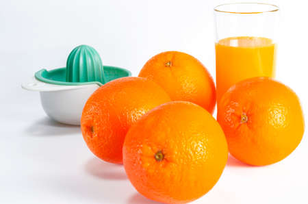 Ripe bio oranges and a glass of fresh squeezed orange juice on white wooden background. Organic Sicilian oranges. glass of fresh orange juice with fresh fruits on white backgroundの写真素材