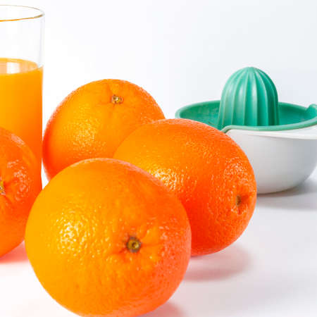 Ripe bio oranges and a glass of fresh squeezed orange juice on white wooden background. Organic Sicilian oranges. glass of fresh orange juice with fresh fruits on white backgroundの写真素材