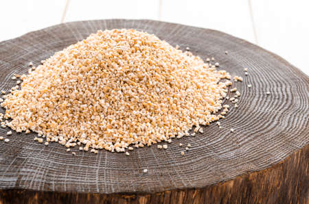 Raw dried broken barley cereal grain texture background macro closeup. Barley groats, coarse barley semolina.の写真素材