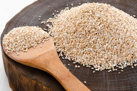 Raw dried broken barley cereal grain texture background macro closeup. Barley groats, coarse barley semolina.の写真素材