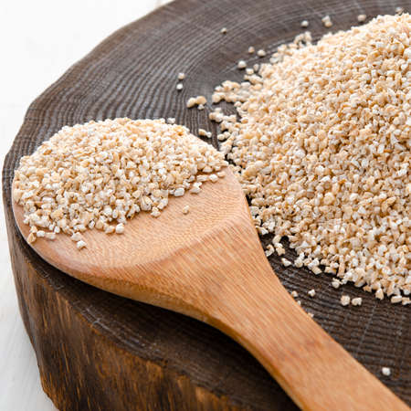 Raw dried broken barley cereal grain texture background macro closeup. Barley groats, coarse barley semolina.の写真素材