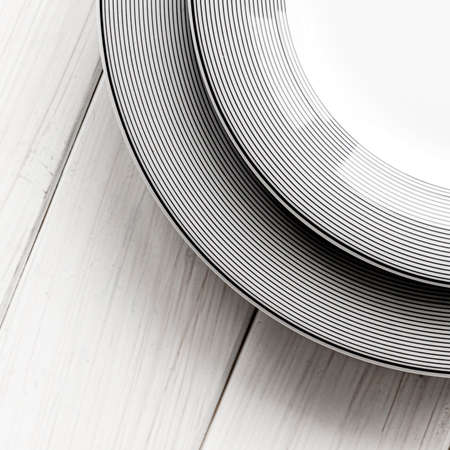 The modern classical porcelain set of plates stands on a white wooden tableの写真素材