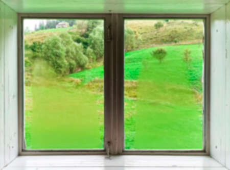 Blurred. A window. view through a window to a wonderful green mountain landscape on vacationの写真素材