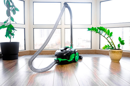 construction cleaning service. Light green vacuum cleaner on a window backgroundの写真素材