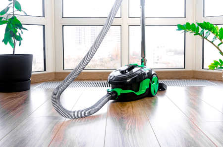 construction cleaning service. Light green vacuum cleaner on a window backgroundの写真素材