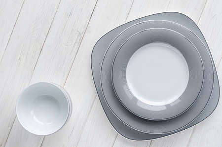 The modern classical porcelain set of plates stands on a white wooden tableの写真素材