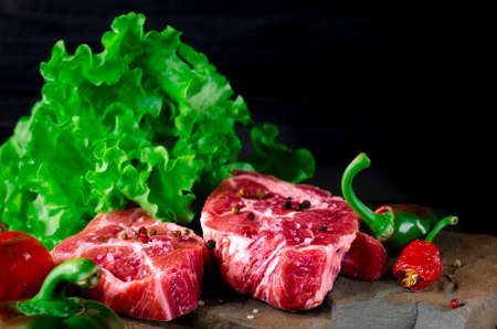 Two classic fresh ribeye steak on stone with herbs peppercorns over gray stone surface background top view. foodの写真素材