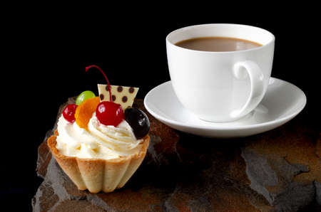 cup of coffee and delicious cake on black background. Close-upの写真素材