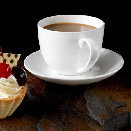 cup of coffee and delicious cake on black background. Close-upの写真素材