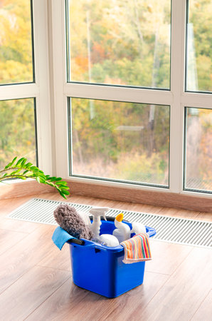 Household cleaners on wooden floor on panoramic window background, home care or household conceptの写真素材
