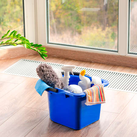 Household cleaners on wooden floor on panoramic window background, home care or household conceptの写真素材