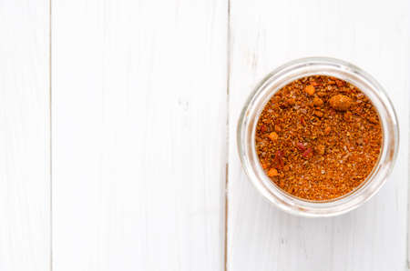 Seasoning. Bright Georgian Svan salt in a glass jar stands on a white wooden tableの写真素材