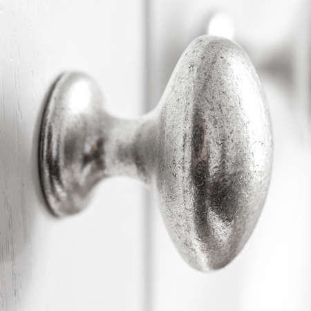 Close up of crome knobs on painted kitchen, wardrobe doors. Interior object photoの写真素材