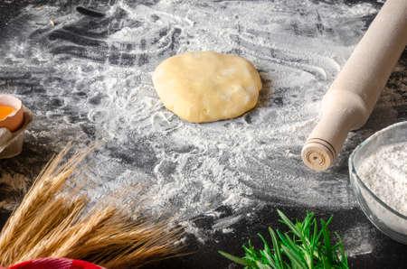 Dough, flour with accessories for the kitchen in the composition on the kitchen tableの写真素材