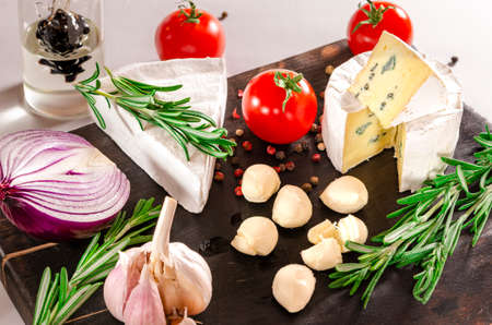 Cheese and tomatoes on wooden desk. Close-up shoot.の写真素材