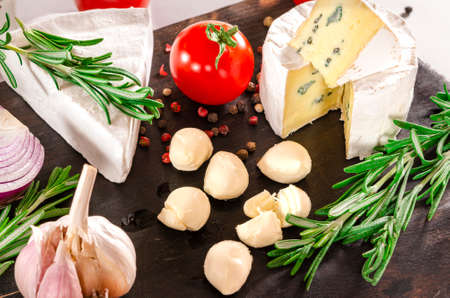 Cheese and tomatoes on wooden desk. Close-up shoot.の写真素材