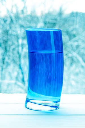 Pouring clear water into glass on nature backgroundの写真素材