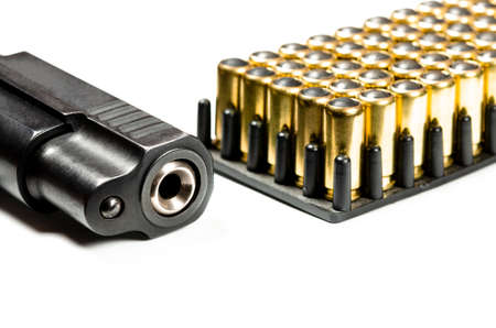 photo of a black pistol and bullets on a white background. Weaponsの写真素材