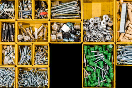 A set of bolts and self-tapping screws for mounting and assembling furniture for home and office. Many storage compartments filled with builders accessories. Arranged neatly and organizedの写真素材