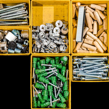 A set of bolts and self-tapping screws for mounting and assembling furniture for home and office. Many storage compartments filled with builders accessories. Arranged neatly and organizedの写真素材