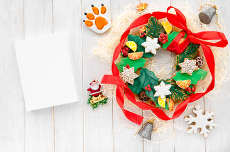 Christmas card with space for text. A Christmas gingerbread in the shape of a Christmas wreath lies on a white wooden backgroundの写真素材