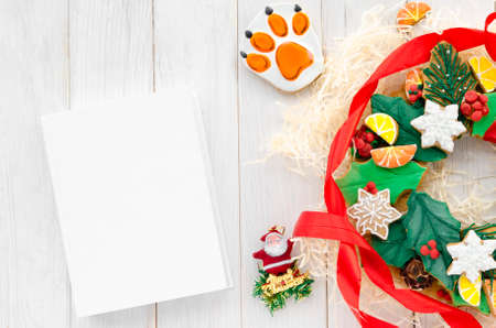 A Christmas gingerbread in the shape of a Christmas wreath lies on a wooden background. Christmas card with space for text. Decorative composition of a Christmas wreath, gingerbread cookiesの写真素材