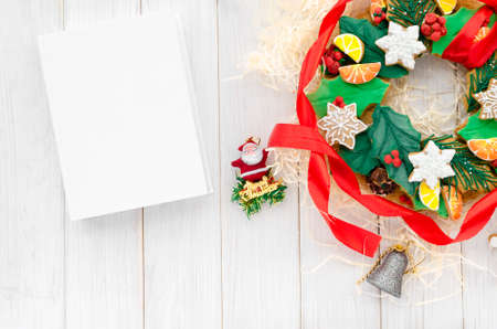 Christmas card with space for text. A Christmas gingerbread in the shape of a Christmas wreath lies on a white wooden backgroundの写真素材