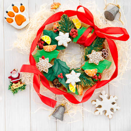 A Christmas gingerbread in the shape of a Christmas wreath lies on a wooden background. Christmas card with space for text. Decorative composition of a Christmas wreath, gingerbread cookiesの写真素材