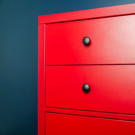 Interior design. Red wooden chest of drawers in Scandinavian style against a blue wallの写真素材