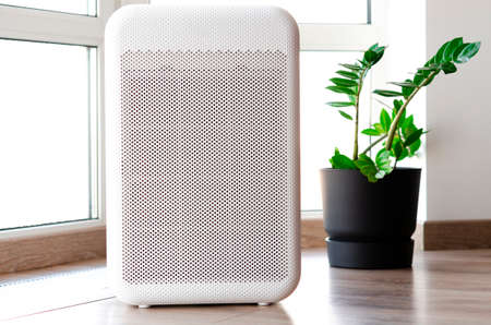 Air purifier in cozy home for filter and cleaning removing dust PM2.5 HEPA and virus in home, for fresh air and healthy Wellness life, Air Pollution Conceptの写真素材