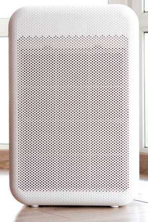 Air purifier in cozy home for filter and cleaning removing dust PM2.5 HEPA and virus in home, for fresh air and healthy Wellness life, Air Pollution Conceptの写真素材